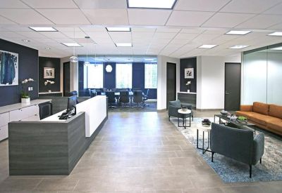 Spacious reception area with a sleek grey desk and modern lounge seating.