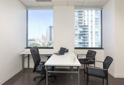 Internal three-person office suite with white desks and large windows.