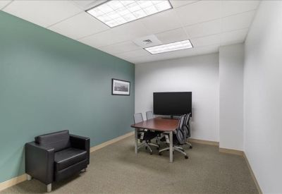 Minimalist white reception desk with modern black pendant lights and wooden paneling.