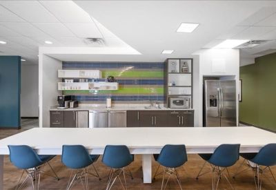 Kitchenette area with a breakfast bar and blue chairs.