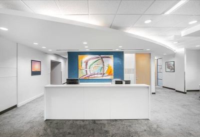 Sleek white reception desk backed by a vibrant abstract painting.