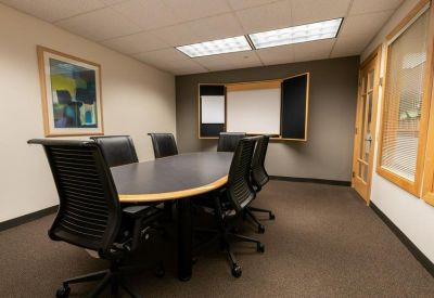 Meeting room with oval table and fold-out whiteboard cabinet.