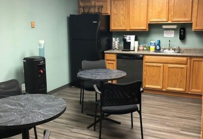 Reception area with high-top tables and a view of the wooden staircase.