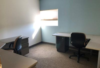 Private office with two desks and a light blue feature wall.