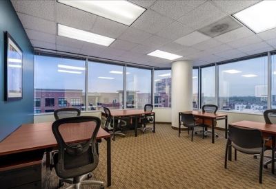 Spacious open-plan workspace with multiple desks and panoramic city views.