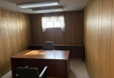 Private office featuring wood-paneled walls and a matching wooden desk.