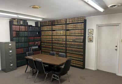Spacious wood-paneled law library with central conference table and legal volumes.
