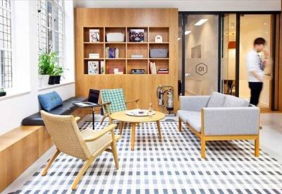 Bright communal lounge with patterned rug and stylish mid-century furniture.