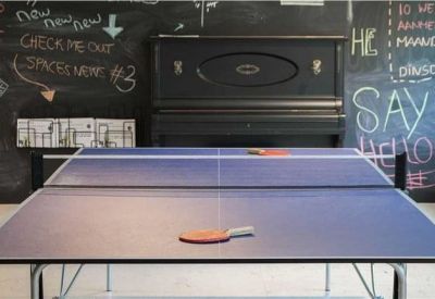 Breakout room with a ping-pong table and chalkboard walls.