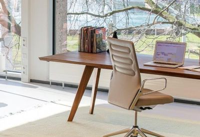 Modern private workstation with a wooden desk and views of lush green trees.