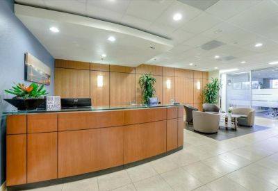 Modern reception area with wooden desk and seating.
