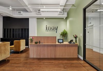 Bright reception area featuring a fluted wood desk and olive green feature wall.
