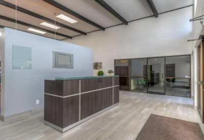 Modern reception desk with wood paneling and bright overhead lighting.