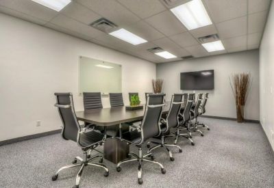 Professional conference room with a long dark table and ergonomic mesh chairs.