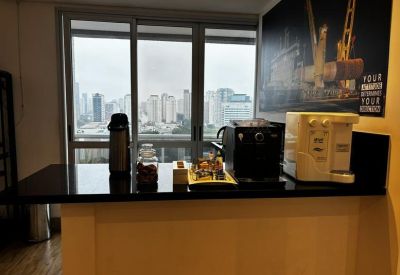 Communal coffee station with espresso machine and snacks overlooking the city.