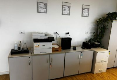 Office utility area featuring a printer, storage cabinets, and wall calendars.