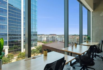 Dedicated workstations with views of the city through floor-to-ceiling windows.