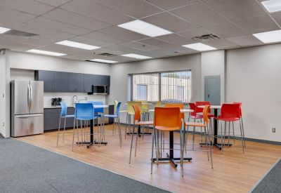 Vibrant communal kitchen and break area with colorful high-top seating.