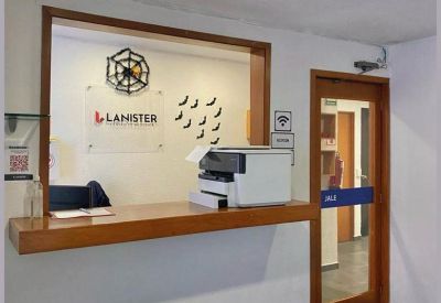 Branded reception area with a wooden counter, printer, and glass door leading to a hallway.