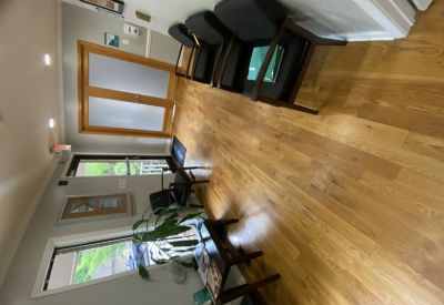 Reception waiting area with comfortable seating and polished wood floors.