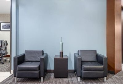 Two comfortable chairs in a lounge area with a small table.