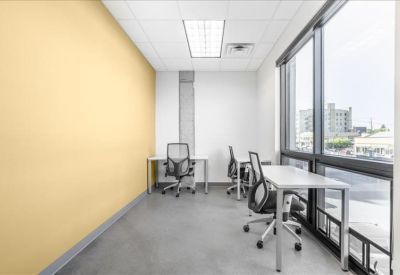 Private office with a yellow feature wall and large windows.