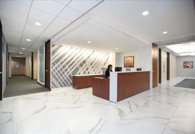Bright reception area featuring a wood-fronted desk and a striking geometric feature wall.