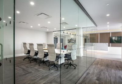 Large boardroom at Harbourfront Business Centre with a white table and grey ergonomic chairs.