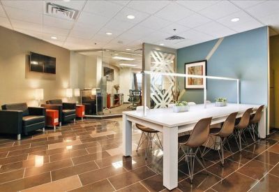 Bright communal lounge with a long high-top table and comfortable armchair seating.