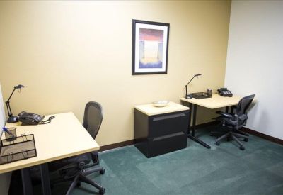 Two-person internal office featuring separate desks and a shared filing cabinet.