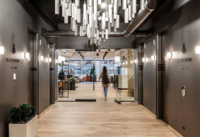 Building entrance with wood floors, dark walls, and a glass-enclosed lobby area.