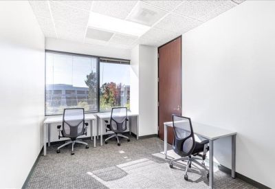 Private office with three workstations and large windows.