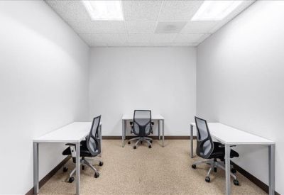 Windowless internal office suite with three modern workstations.