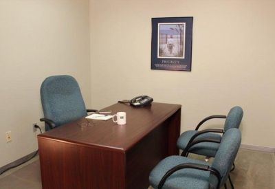 Small private office with a desk and two guest chairs.
