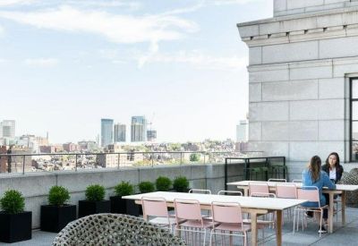 Rooftop terrace with pink seating, planters, and a skyline view.