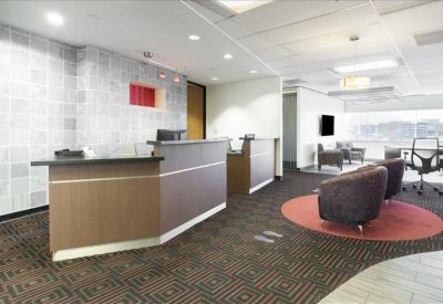 Professional reception desk area with a warm patterned carpet and plush lounge seating.