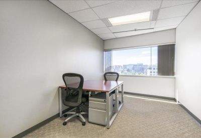 Private office featuring two workstations and a large window with city views.