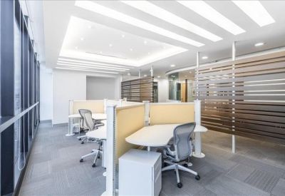 Open-plan workspace with modern desks and a slatted wood partition.