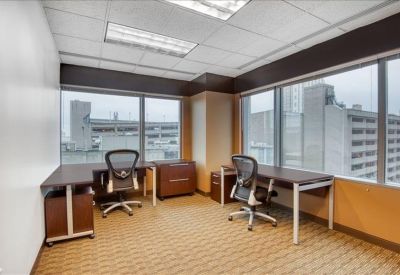 Spacious two-person office suite with corner windows and city views.
