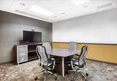 Professional small meeting room with a square table and four ergonomic chairs.