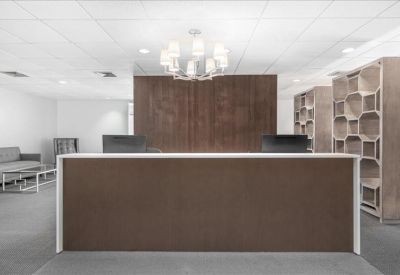 Professional reception area with a wood-fronted desk and chandelier.