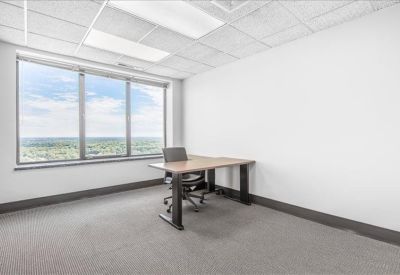 Private office with a large window and wooden desk.