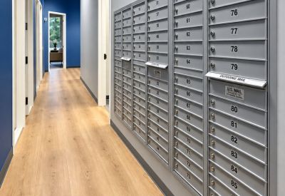 Bright hallway lined with blue and grey walls featuring a wall-mounted mailbox system.