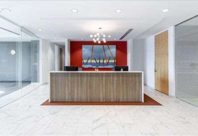 Modern reception area with a wood-panelled desk and vibrant red feature wall.
