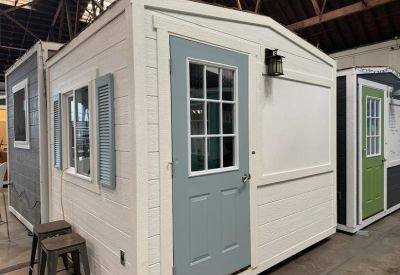 White micro-office with a light blue door and grey shutters.