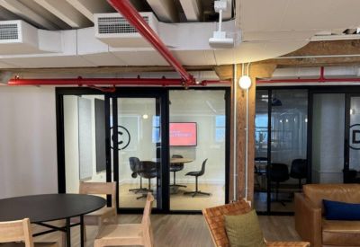 Meeting pod and common area at 53 Beach Street with industrial red piping on the ceiling.