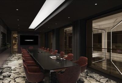 Dark, sophisticated boardroom featuring a long black table and red velvet chairs.