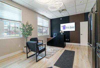 Reception area featuring a sleek black and wood desk and comfortable seating.