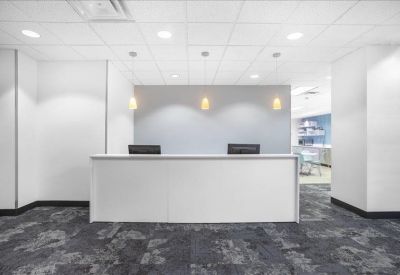 Modern white reception desk with minimalist pendant lighting.