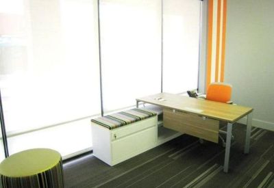 Single workstation with an orange chair and a window-side storage bench.